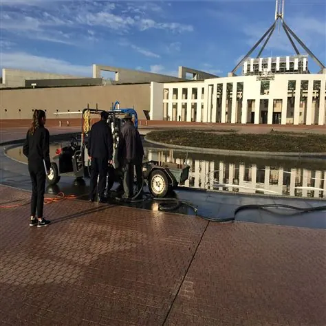 A work crew operating equipment on a public forecourt